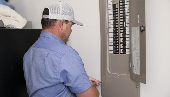 Technician Looking At Electric Panel